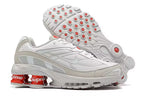 Nike-skor i vitt och orange med Supreme-märke.